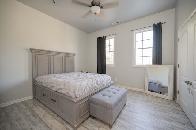 bedroom featuring visible vents, light wood-type flooring, and baseboards