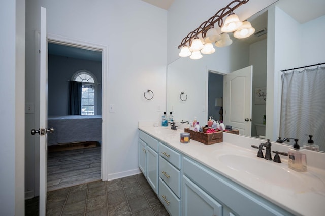 full bath featuring double vanity, baseboards, visible vents, and a sink