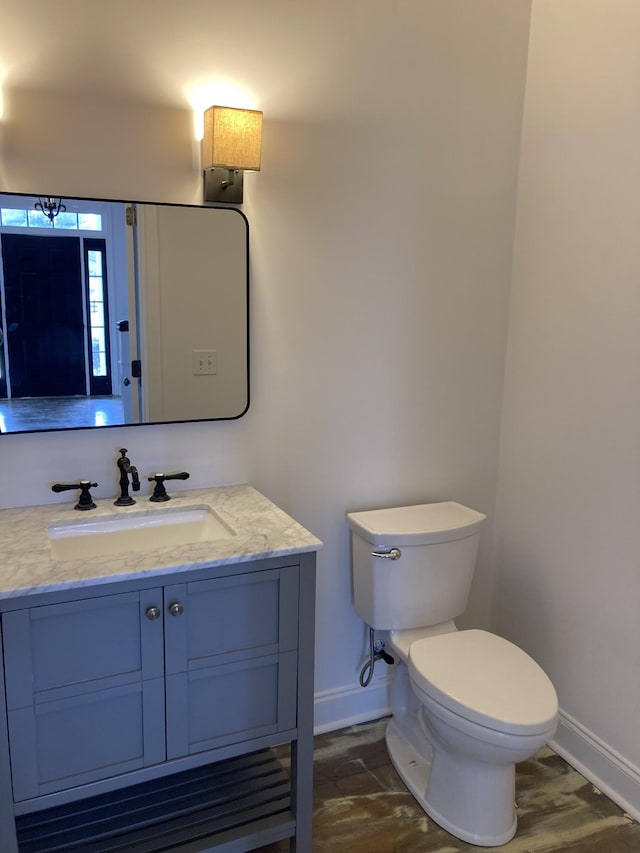 bathroom featuring toilet, baseboards, and wood finished floors