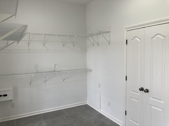 spacious closet with dark tile patterned floors