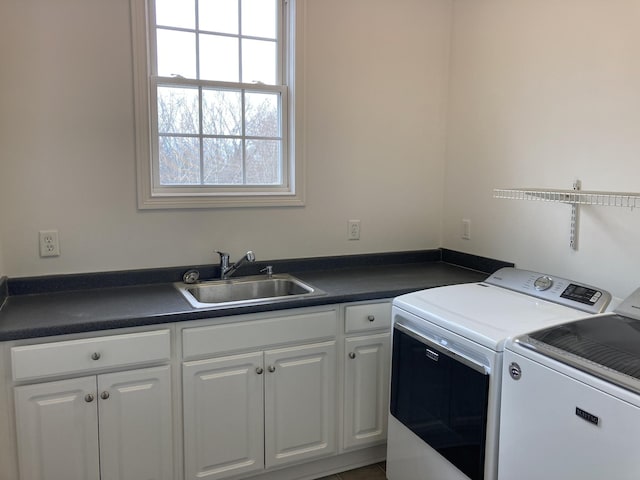 washroom with a sink, cabinet space, and washing machine and clothes dryer