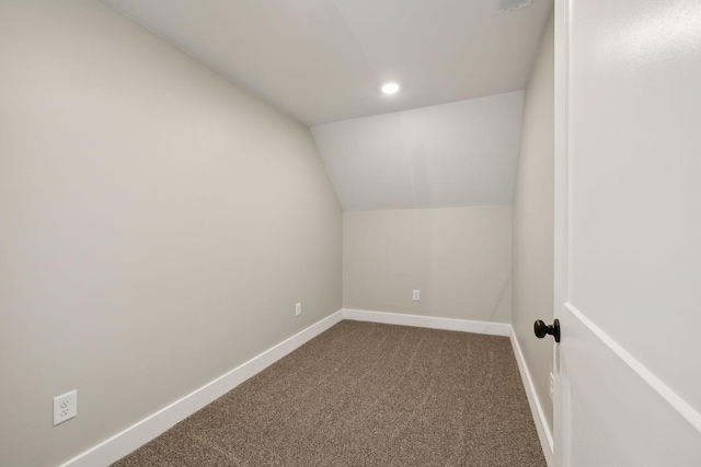 interior space with vaulted ceiling and carpet