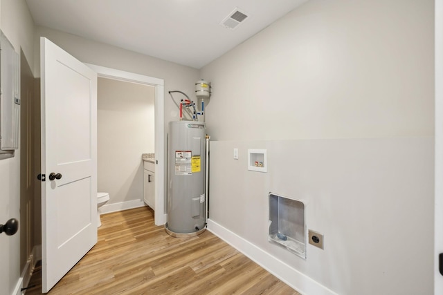 clothes washing area featuring washer hookup, electric water heater, light hardwood / wood-style floors, and hookup for an electric dryer