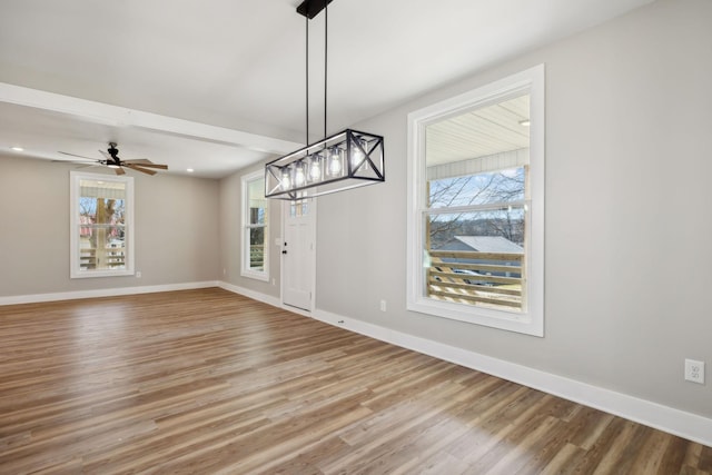 unfurnished dining area with hardwood / wood-style floors and ceiling fan