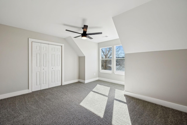 additional living space with dark colored carpet and ceiling fan