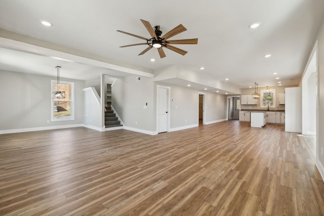 unfurnished living room featuring hardwood / wood-style floors and ceiling fan