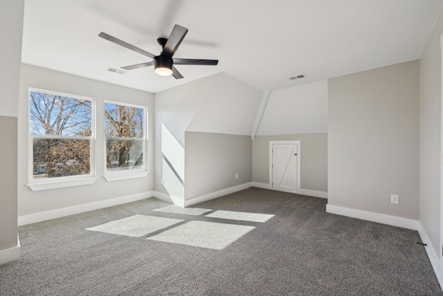 additional living space with ceiling fan, lofted ceiling, and dark colored carpet