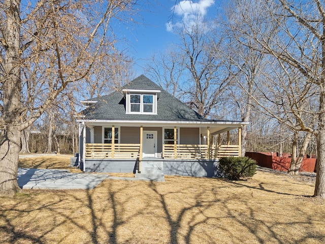 view of front facade with a porch, central AC, and a front lawn