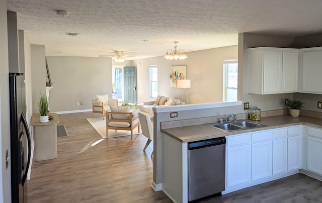 kitchen with wood-type flooring, sink, white cabinets, stainless steel dishwasher, and black fridge