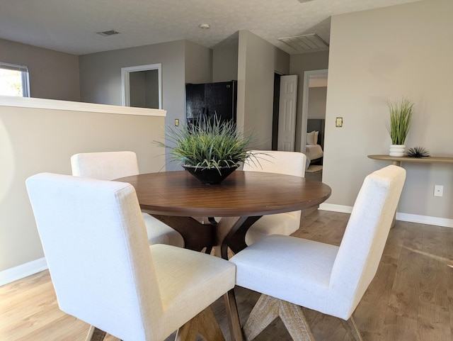 dining area featuring hardwood / wood-style floors and a textured ceiling