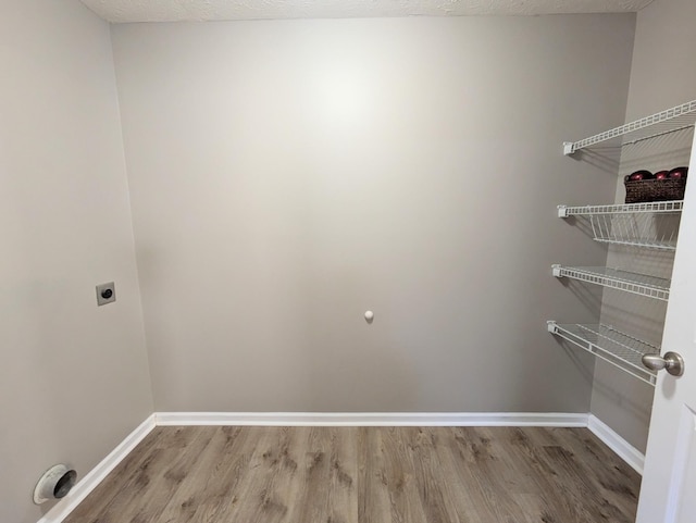 interior space featuring hardwood / wood-style floors, hookup for an electric dryer, and a textured ceiling