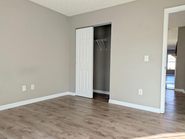 unfurnished bedroom featuring light hardwood / wood-style floors and a closet