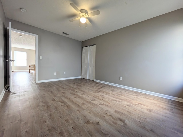 unfurnished bedroom featuring a closet, ceiling fan, and light wood-type flooring