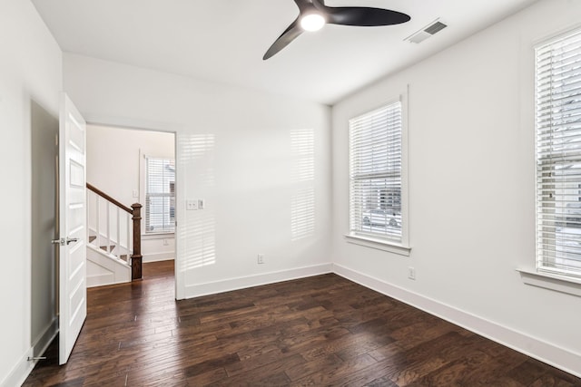 unfurnished room featuring ceiling fan, dark hardwood / wood-style floors, and a wealth of natural light