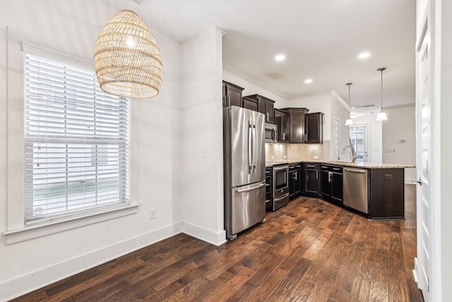 kitchen with dark hardwood / wood-style flooring, hanging light fixtures, kitchen peninsula, stainless steel appliances, and light stone countertops