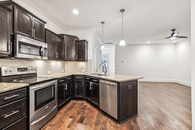 kitchen featuring sink, hanging light fixtures, kitchen peninsula, and appliances with stainless steel finishes