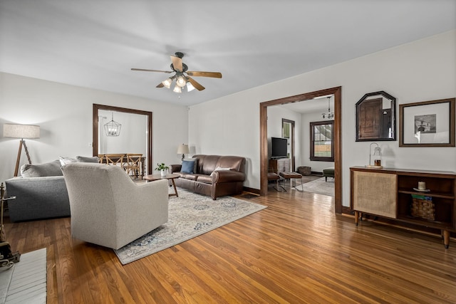 living room featuring hardwood / wood-style flooring and ceiling fan with notable chandelier