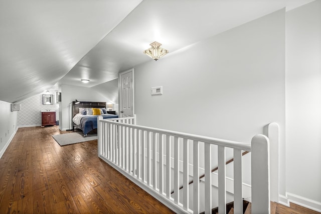 hall with dark hardwood / wood-style floors and vaulted ceiling