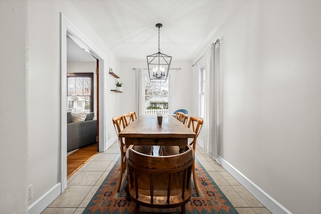 dining room with light tile patterned flooring and a notable chandelier