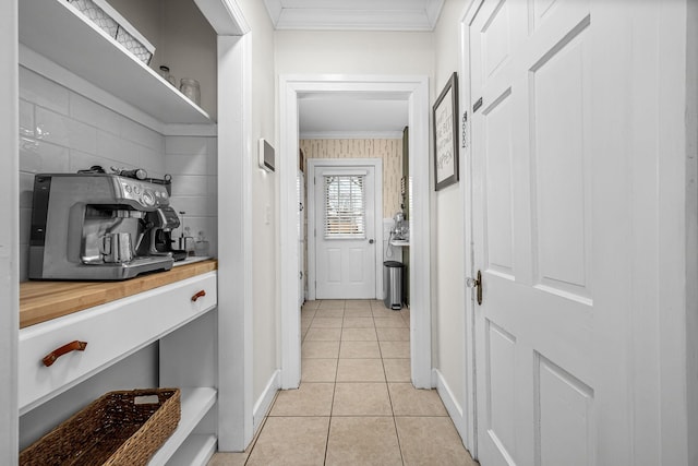 hallway with light tile patterned floors and crown molding