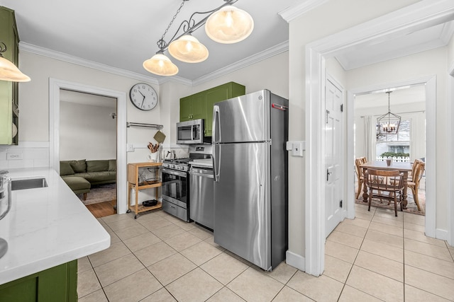 kitchen with light tile patterned flooring, appliances with stainless steel finishes, a notable chandelier, green cabinetry, and crown molding