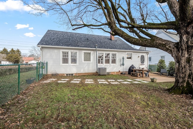 rear view of property featuring central AC unit, a patio area, and a lawn