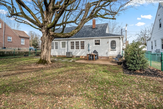 rear view of property with a yard, central AC, and a patio area