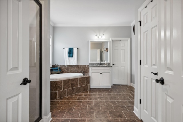 bathroom featuring vanity, tiled tub, and ornamental molding