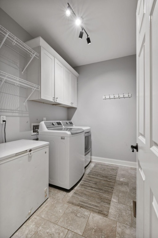 laundry area featuring washing machine and dryer and cabinets