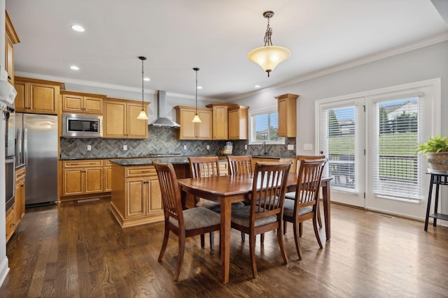 dining area with ornamental molding, sink, and dark hardwood / wood-style flooring