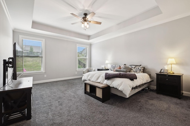 carpeted bedroom with a raised ceiling, ornamental molding, and ceiling fan