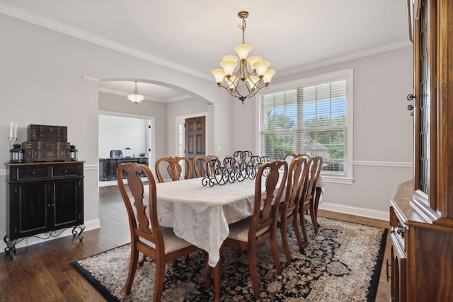 dining room with a notable chandelier, dark wood-type flooring, and ornamental molding