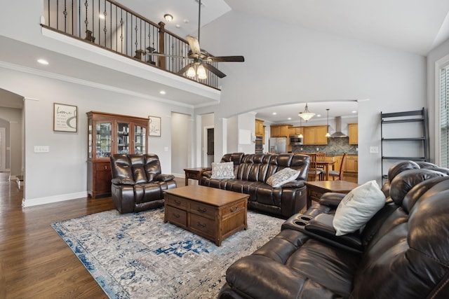 living room with wood-type flooring, crown molding, ceiling fan, and high vaulted ceiling