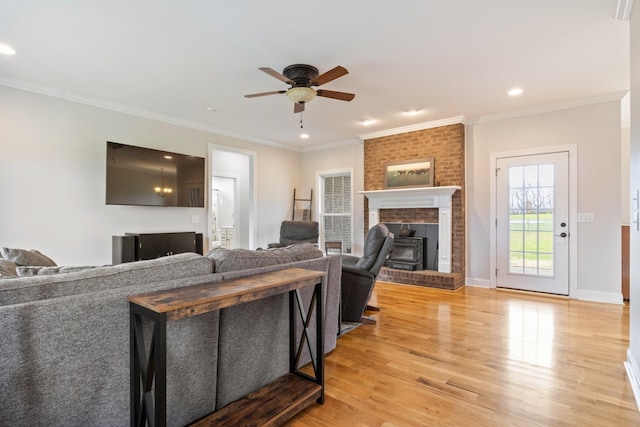 living room featuring crown molding, light hardwood / wood-style floors, and ceiling fan