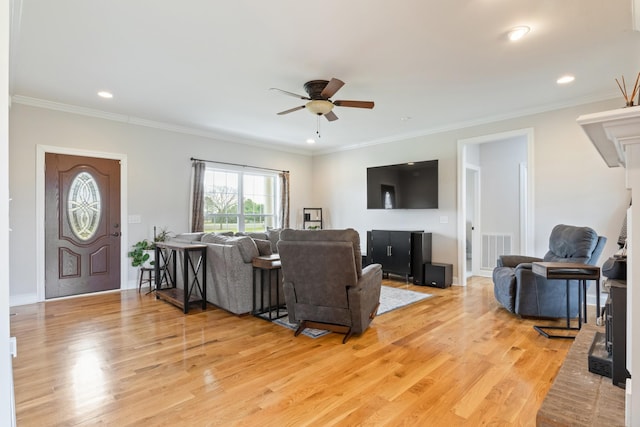 living room featuring crown molding, ceiling fan, and light hardwood / wood-style flooring