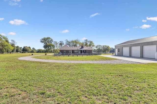 view of yard featuring a garage and an outbuilding