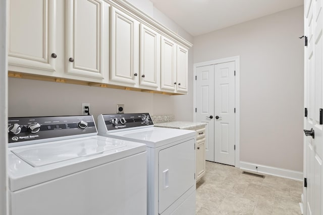 laundry room featuring cabinets and washer and dryer