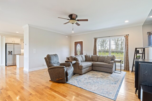 living room with crown molding, ceiling fan, and light hardwood / wood-style flooring