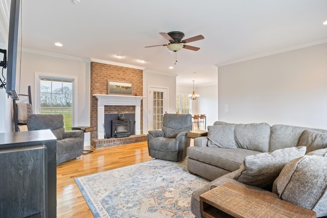 living room featuring crown molding, a healthy amount of sunlight, and light hardwood / wood-style flooring