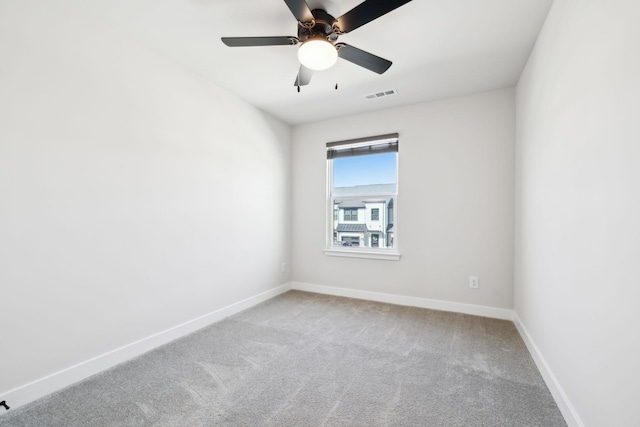 spare room with ceiling fan and light carpet