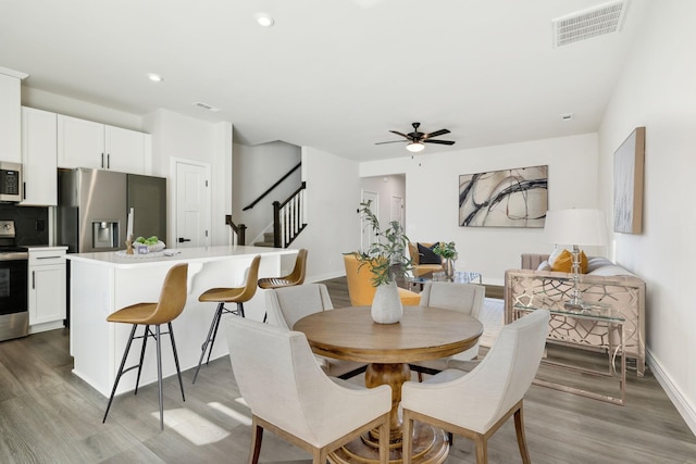 dining room with light hardwood / wood-style flooring and ceiling fan