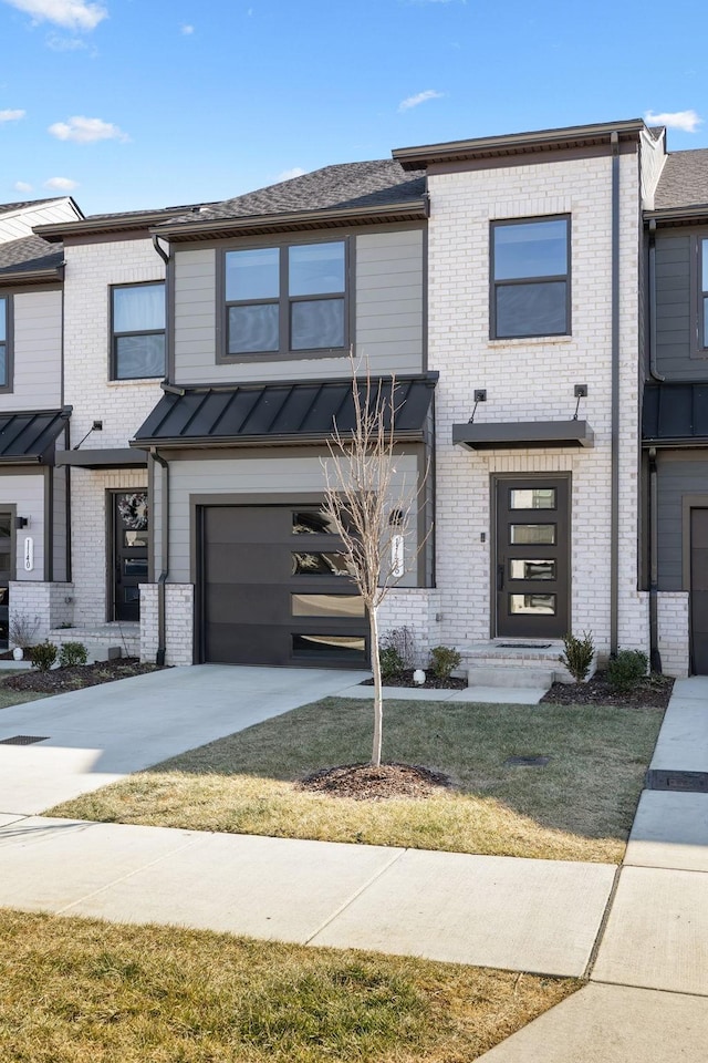 view of property featuring a garage and a front lawn