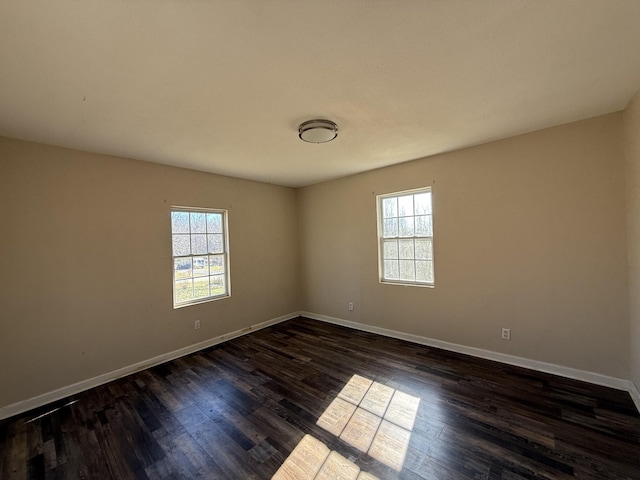 unfurnished room with dark hardwood / wood-style flooring