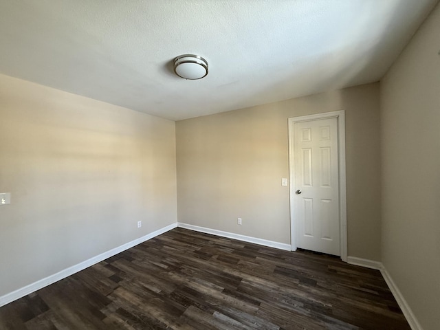 empty room featuring dark hardwood / wood-style flooring and a textured ceiling