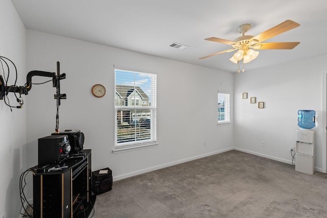 misc room with carpet flooring, a wealth of natural light, and ceiling fan