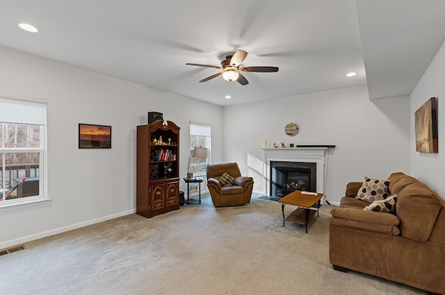 carpeted living room with ceiling fan