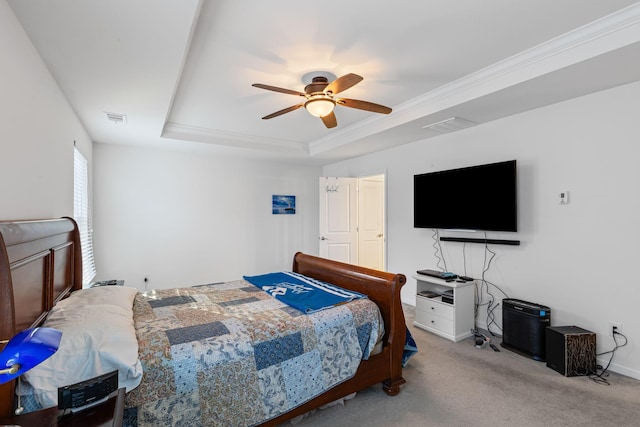 bedroom with a tray ceiling, ornamental molding, light colored carpet, and ceiling fan