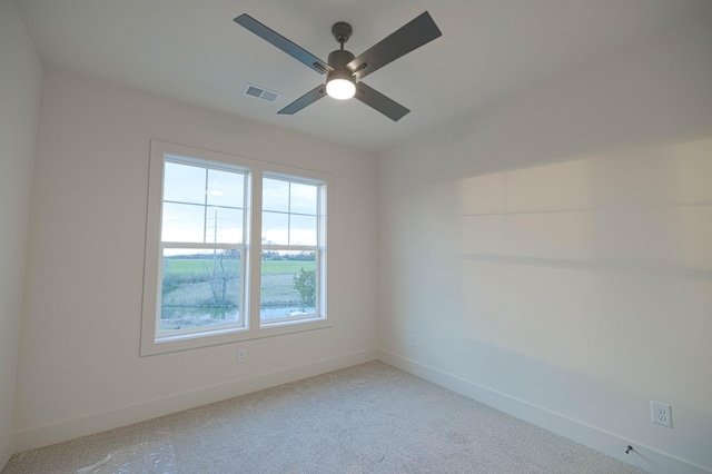 spare room with carpet floors, baseboards, visible vents, and ceiling fan