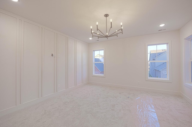 spare room featuring baseboards, visible vents, light colored carpet, a notable chandelier, and recessed lighting