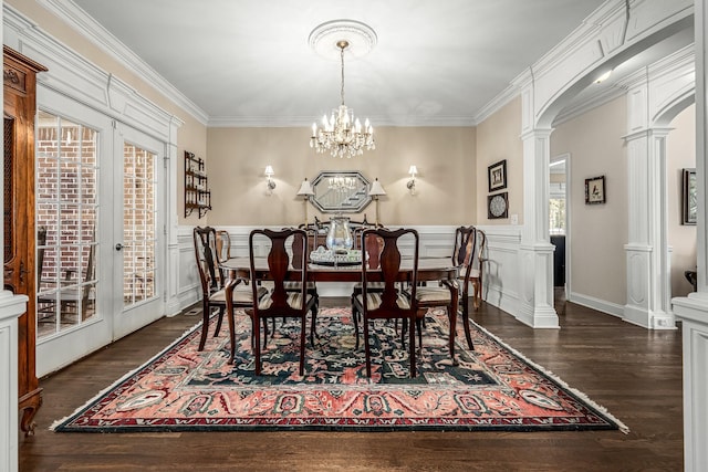 dining space featuring french doors, ornamental molding, dark wood-type flooring, and ornate columns